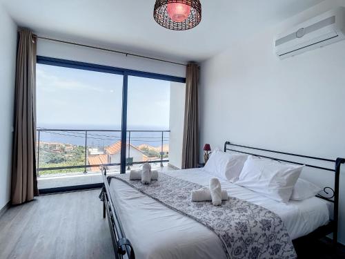 a bedroom with a bed and a large window at Casa Teixeira by Atlantic Holiday in Estreito da Calheta
