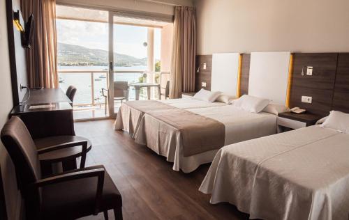 a hotel room with two beds and a balcony at Seramar Hotel Comodoro Playa in Palmanova