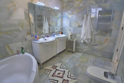 a bathroom with two sinks and a tub and a toilet at Villa Golondrinas - Private villa to sleep 6 in Nerja