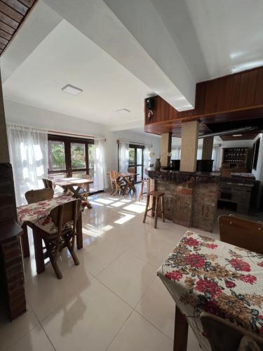 uma grande cozinha com mesas e cadeiras num quarto em Rodeio das Lagoas em Cambará