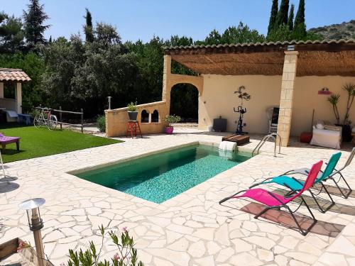 une piscine avec deux chaises et une maison dans l'établissement Villa charmante à Mérindol avec piscine privée, à Mérindol
