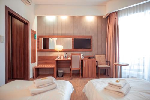 a hotel room with two beds and a desk at Hotel Centrum Malbork in Malbork