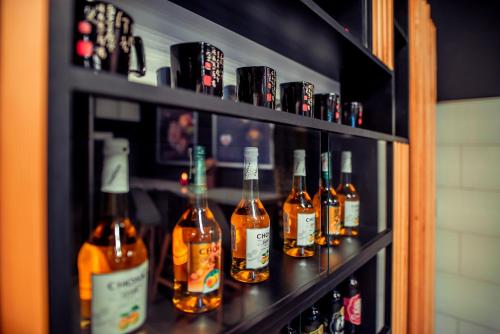 a shelf with many bottles of alcohol on it at Hotel Centrum Malbork in Malbork