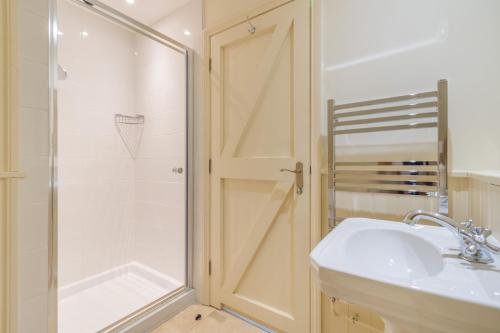 a bathroom with a shower and a sink and a toilet at Beachy Barn in Eastdean