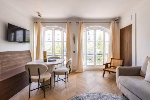 un salon avec une table, des chaises et un canapé dans l'établissement Central&Spacious 2BD Apart for 6, à Paris