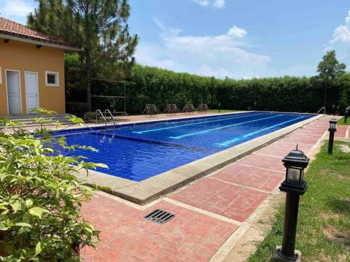 una piscina en un patio junto a una casa en A comfy retreat in the heart of Orani, Bataan en Orani