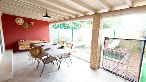 ein Esszimmer mit einem Tisch und einem Balkon in der Unterkunft Impression du Sud Gîte 2 in Saint-Rémy-de-Provence