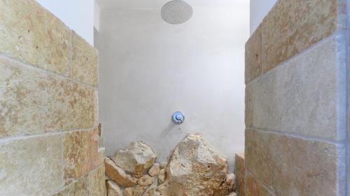 a bathroom with a shower with a stone wall at VILLA SOLELUNA 7&1, Emma Villas in Marittima
