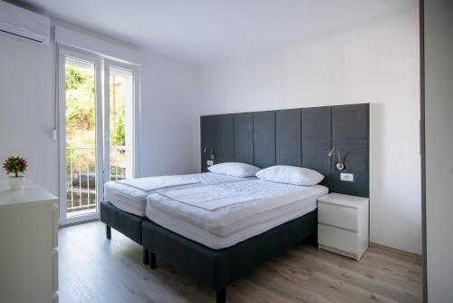 - une chambre avec un grand lit et une tête de lit noire dans l'établissement Boby Apartment, à Dubrovnik