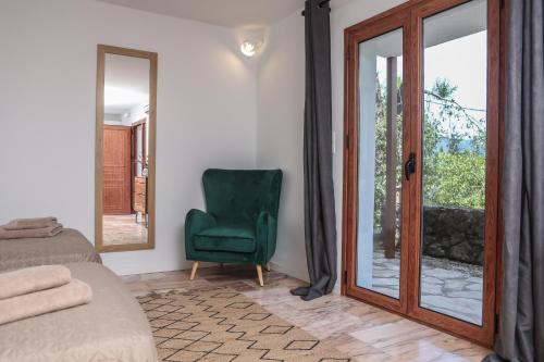 a bedroom with a green chair and a mirror at Angela's flat studio - Dassia Corfu in Kato Korakiana