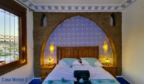 a bedroom with a bed with a blue tile wall at Casa Meftah Blue in Chefchaouene