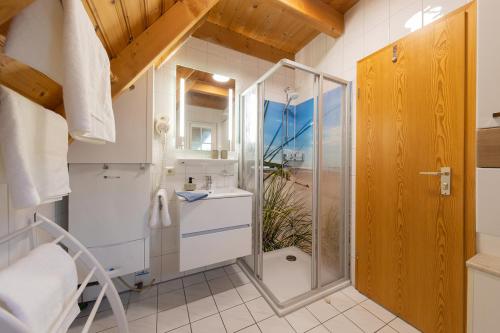 ein Bad mit einer Dusche und einer Glasduschkabine in der Unterkunft MS 18 - Strandvogt 3 Komfort in Dorum Neufeld