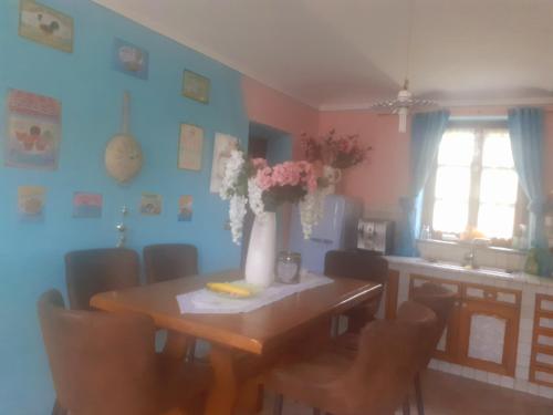 a dining room table with a vase of flowers on it at Villa "Piemonte" in Tigliole