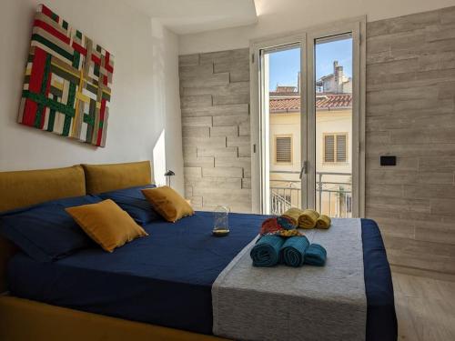 sypialnia z niebieskim łóżkiem i dużym oknem w obiekcie Santeria Modern Loft w mieście Tortolì