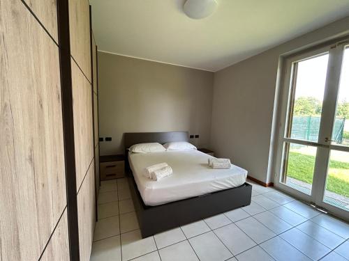 1 dormitorio con cama y ventana grande en Appartamento Mimosa - Immobili e Soluzioni Rent, en Brembate