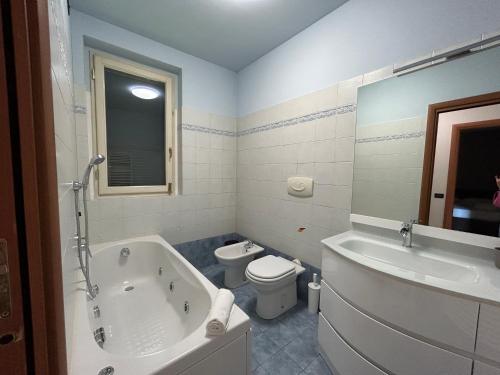 y baño con bañera, aseo y lavamanos. en Appartamento Mimosa - Immobili e Soluzioni Rent, en Brembate