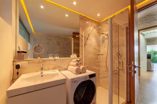 a bathroom with a washing machine and a sink at Villa Alvarium in Schenna