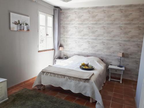 ein Schlafzimmer mit einem Bett und einer Ziegelwand in der Unterkunft La bastide de Cocagne in Rognes