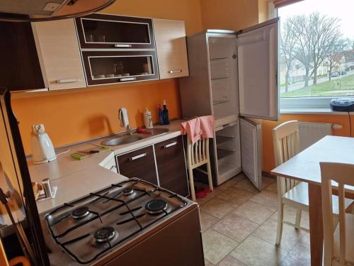 cocina con fogones, fregadero y mesa en Apartament u Margherity, en Ińsko