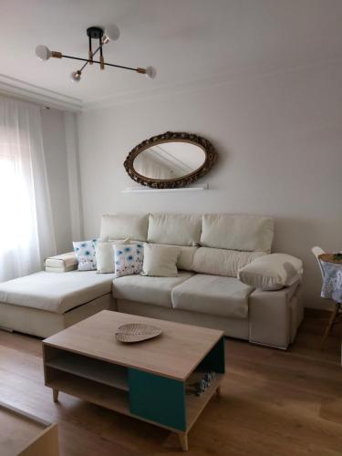 a living room with a white couch and a table at Apartamento Brisa de Santander in Santander