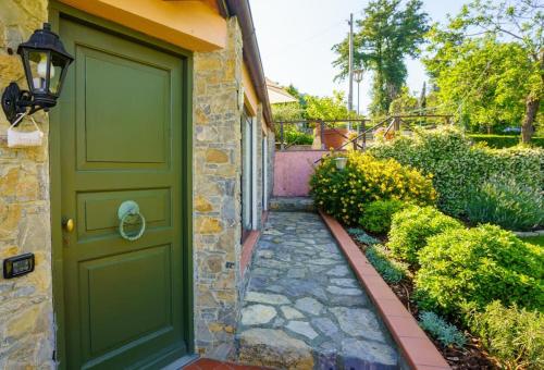 una puerta verde en el lateral de una casa con jardín en I Brichi, un paradiso immerso nella natura., en Lerici