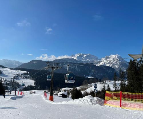a ski slope with a ski lift in the snow at Loft Krämerhaus Annaberg, Dachstein West in Annaberg im Lammertal