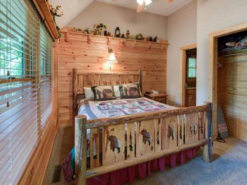 1 dormitorio con 1 cama en una pared de madera en Running Bear, 2 Bedrooms, Sleeps 8, Hot Tub, Gas Fireplace, Pool Table en Gatlinburg