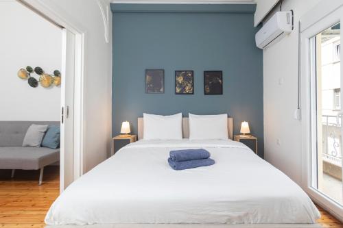 a bedroom with a large white bed with a blue wall at Houseloft Metropolitan Highlight in Thessaloniki