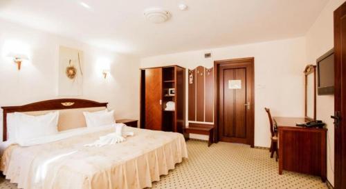 a hotel room with a large bed and a desk at Q Resort and Spa in Săcele