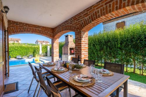 a wooden table and chairs on a patio at Villa Berenice in Butkovići