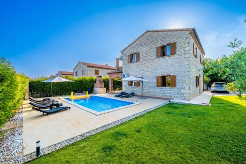 a backyard with a swimming pool and a house at Villa Berenice in Butkovići