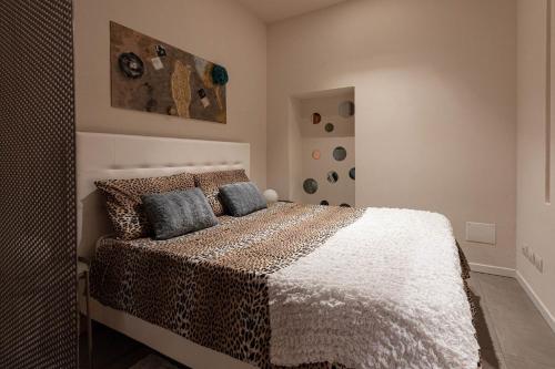 um quarto com uma cama com um cobertor de leopardo em BORGO DEGLI STUDI 7 em Parma