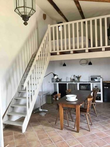 une salle à manger avec une table et un escalier dans l'établissement Uzès proche,charmant pied a terre avec terrasse, à La Bastide-dʼEngras