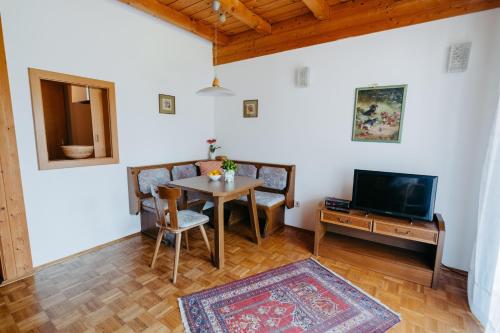a living room with a table and a tv at Villa Fernblick in Velden am Wörthersee