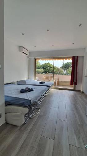 une chambre à l'hôpital avec deux lits et une grande fenêtre dans l'établissement Beach Studio Cannes, à Cannes