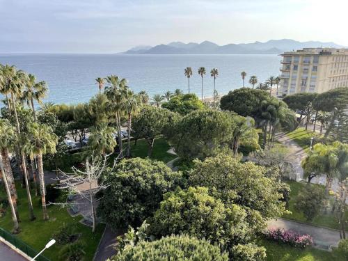 Blick auf einen Park mit Palmen und das Meer in der Unterkunft Beach Studio Cannes in Cannes