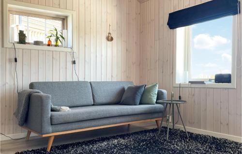 a blue couch in a room with a window at Nice Home In Gol With Kitchen in Golsfjellet