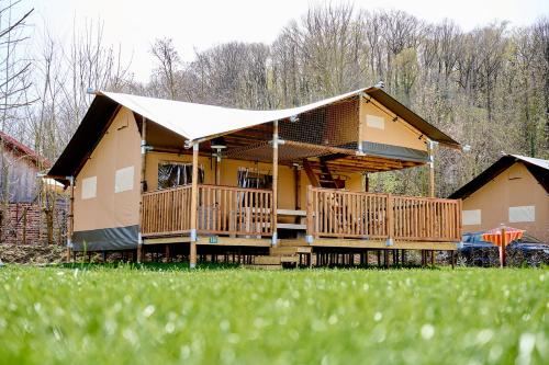 a large house with a porch and a deck at Glamping Valkenburg in Meerssen