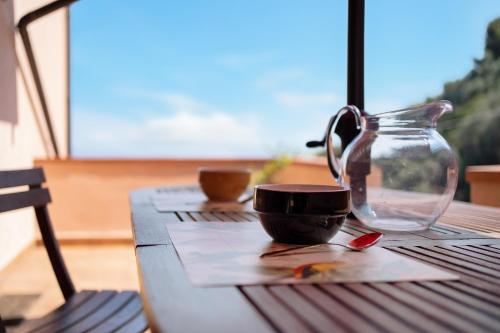 a wooden table with a cup and a glass jar at Casa Scotland in Ventimiglia