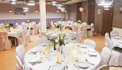a banquet hall with white tables and white chairs at Holiday Inn Trnava by IHG in Trnava