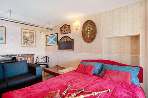 a bedroom with a large pink bed and a chair at Casa Scotland in Ventimiglia