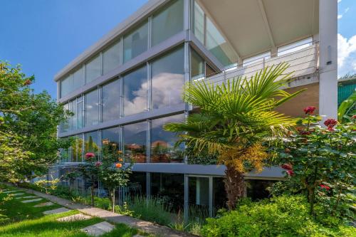 an office building with a palm tree in front of it at Villa Alvarium in Schenna