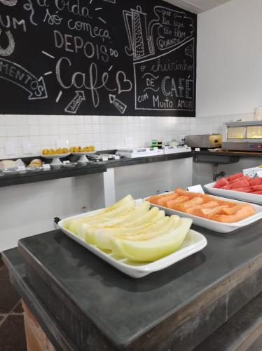 two trays of cheese and other foods on a counter at Pousada Dona Emilia in Brotas