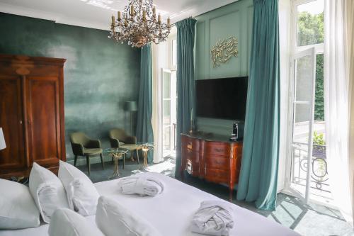 a bedroom with two beds and a flat screen tv at Hôtel Chateau de Maffliers - Demeures de Campagne in Maffliers