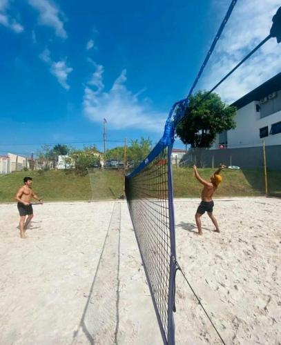 two men playing a game of volleyball on the beach at Pousada Dona Emilia in Brotas