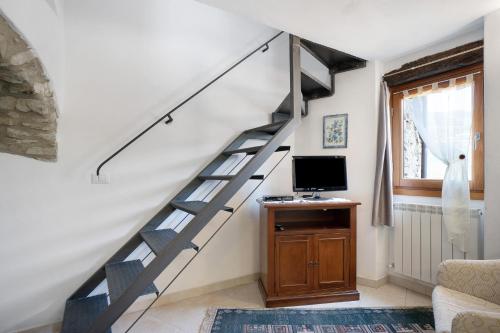 a spiral staircase in a living room with a tv at U Graie in Apricale