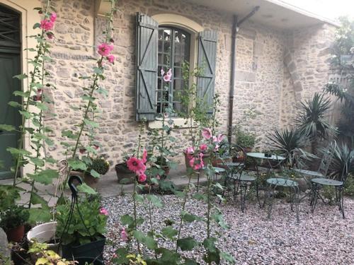 a patio with tables and chairs and flowers in front of a building at château de Paulignan in Trausse
