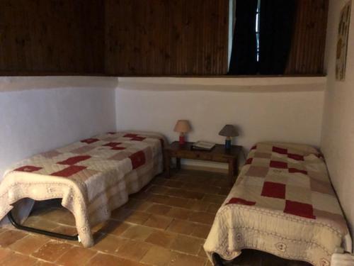a bedroom with two beds and a table and a window at château de Paulignan in Trausse