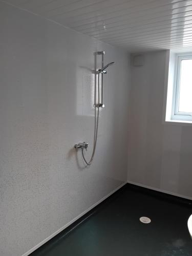 a shower in a white room with a window at Windies apartment 1 in Bridlington