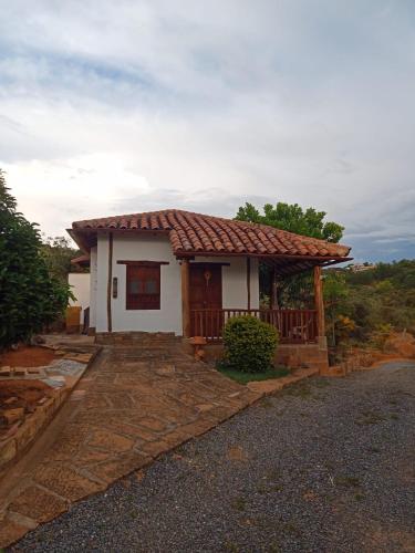 a small white house with a red roof at cabañas villa Angelica in Barichara